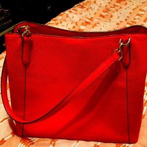 Red/ has a pink undertone kate spade bag .